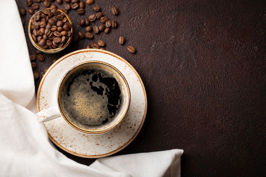 Kaffeetasse garniert mit Kaffeebohnen